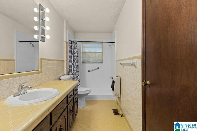 5241 County Road 48, Jemison, AL 35085 - bathroom with tile walls, heating unit, toilet, wainscoting, and vanity