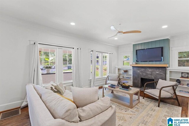 living room featuring ornamental molding, wood finished floors, a large fireplace, recessed lighting, and baseboards
