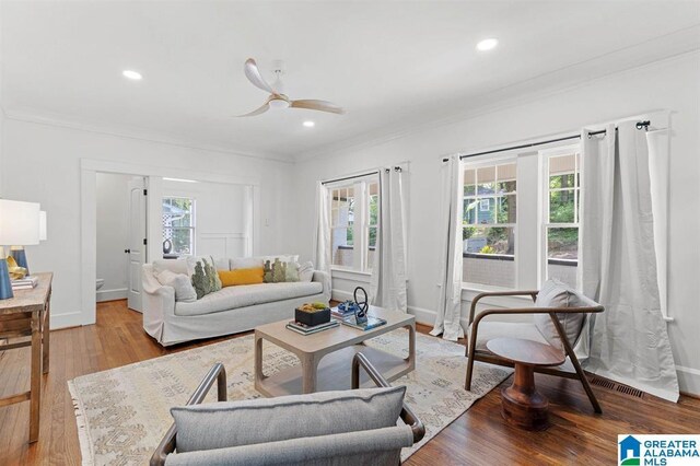 living room with crown molding, wood finished floors, a ceiling fan, recessed lighting, and baseboards