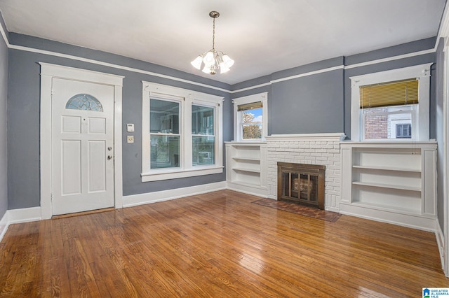 728 41st St, Fairfield, AL 35064 - unfurnished living room with a chandelier, wood finished floors, baseboards, and built in features