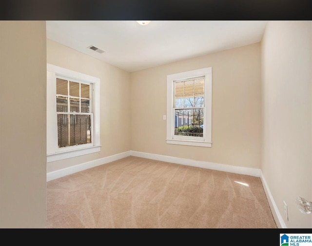 carpeted spare room featuring baseboards