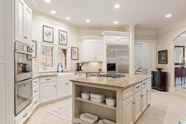 4035 Saint Charles Dr, Hoover, AL 35242 - kitchen with appliances with stainless steel finishes, open shelves, a sink, arched walkways, and backsplash