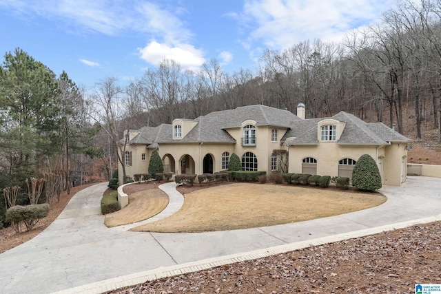 4035 Saint Charles Dr, Hoover, AL 35242 - french provincial home featuring driveway, a chimney, a shingled roof, and stucco siding