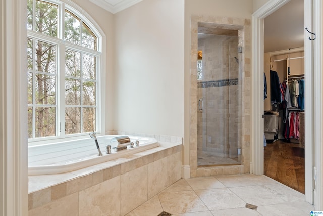4035 Saint Charles Dr, Hoover, AL 35242 - bathroom featuring crown molding, a garden tub, a shower stall, healthy amount of natural light, and a walk in closet