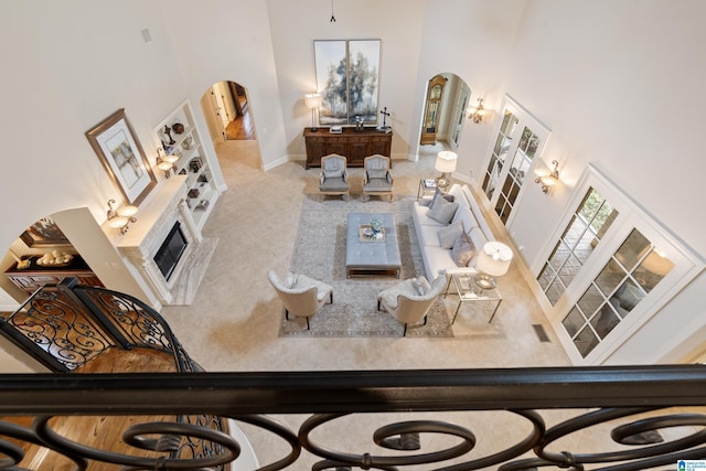 4035 Saint Charles Dr, Hoover, AL 35242 - living room featuring arched walkways, a high ceiling, baseboards, and a glass covered fireplace