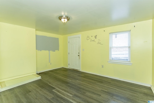 empty room featuring wood finished floors and baseboards