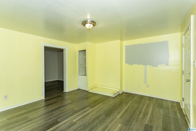 spare room featuring wood finished floors and baseboards