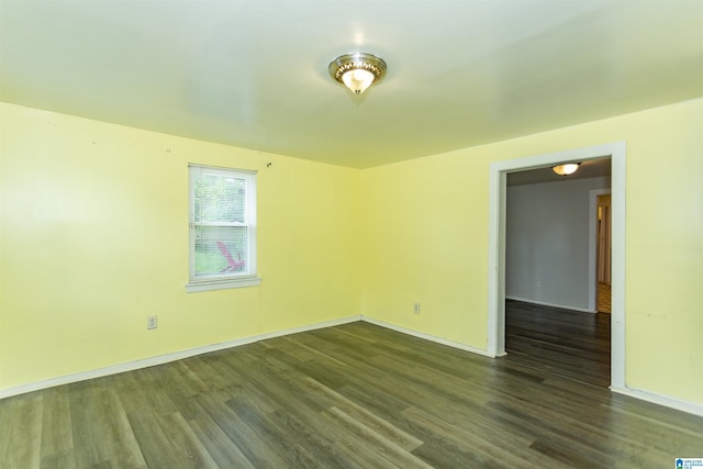 unfurnished room with dark wood finished floors and baseboards