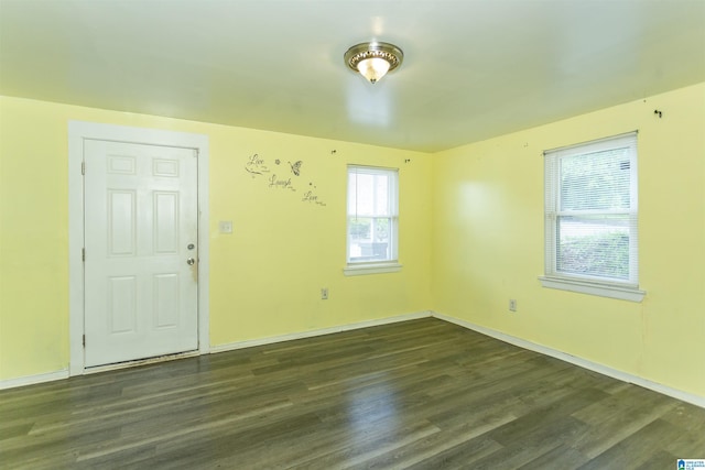 empty room with dark wood-type flooring and baseboards