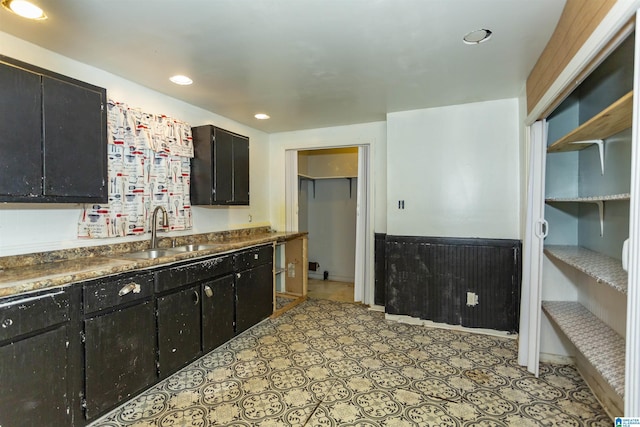 kitchen with a sink, dark cabinetry, recessed lighting, and dark countertops