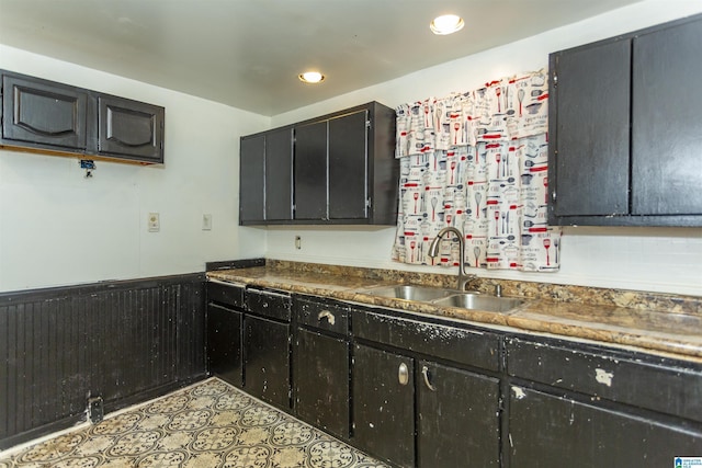 kitchen featuring a sink, recessed lighting, and a wainscoted wall