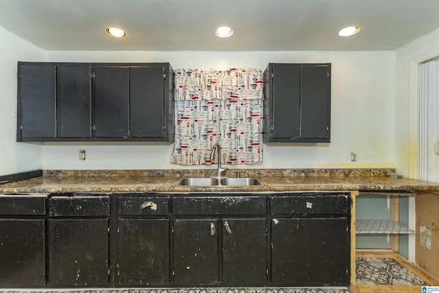 kitchen with a sink, dark countertops, dark cabinetry, and recessed lighting
