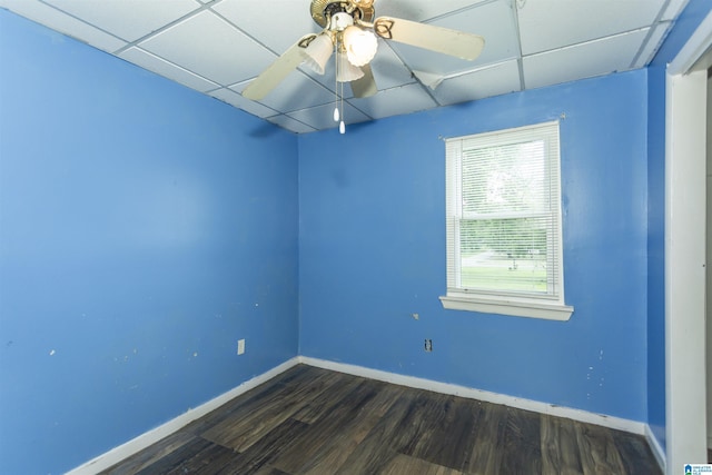 spare room featuring a paneled ceiling, wood finished floors, baseboards, and ceiling fan