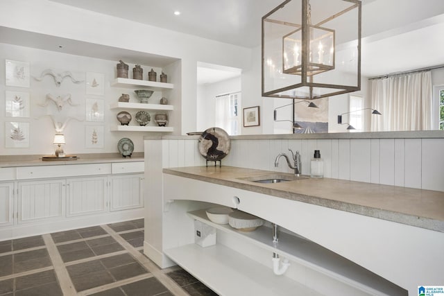 bar featuring a sink, healthy amount of natural light, and hanging light fixtures