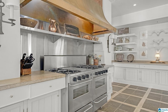 kitchen featuring open shelves, range with two ovens, white cabinetry, light countertops, and recessed lighting