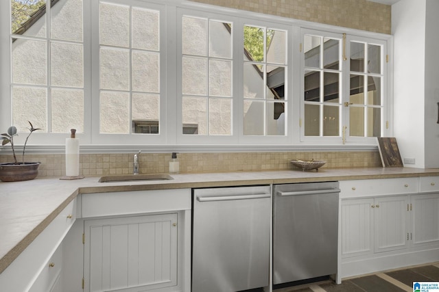 kitchen featuring dishwasher, a sink, backsplash, and light countertops
