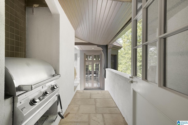 hall featuring stone tile floors and wood ceiling