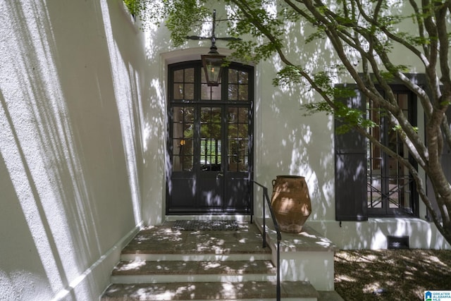 entrance to property with french doors and stucco siding