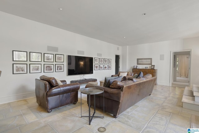 living area featuring stone tile floors and baseboards