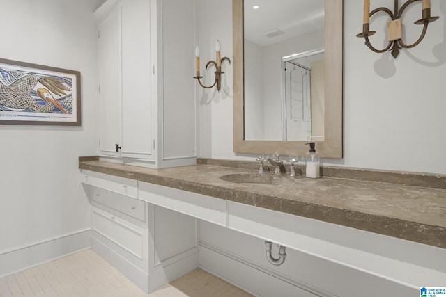 bathroom featuring vanity, tile patterned flooring, and baseboards