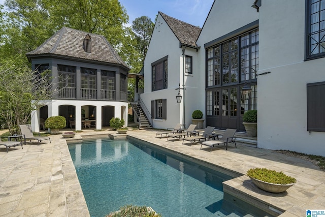 swimming pool featuring a patio area and stairway