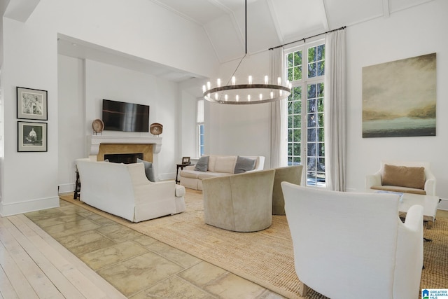 living room with a chandelier, a fireplace, lofted ceiling, baseboards, and wood finished floors