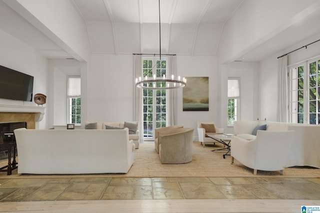 living room with stone tile floors, a chandelier, and a fireplace