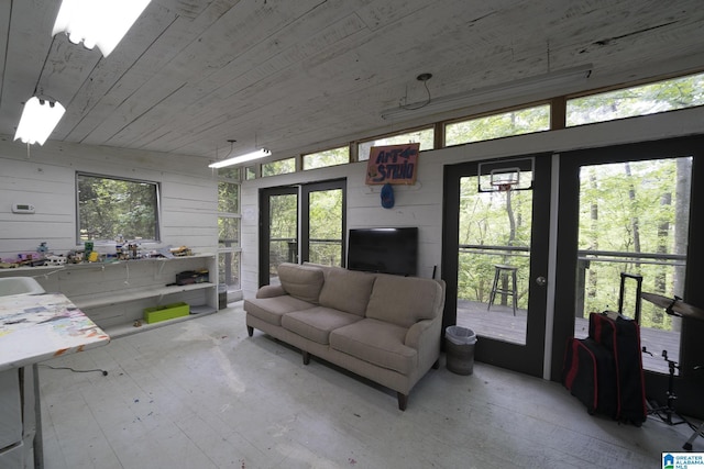living area with light wood-style floors, wooden ceiling, wood walls, and vaulted ceiling