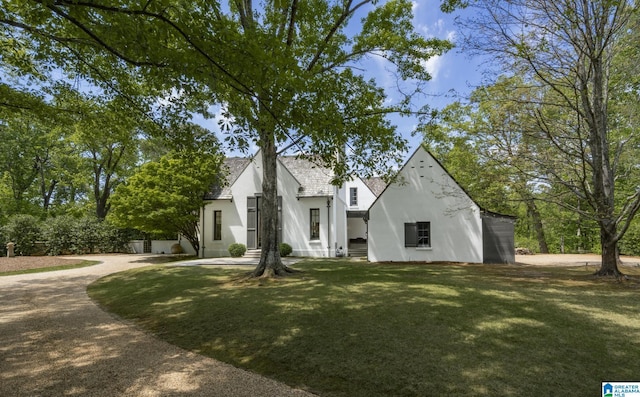 view of front facade with stucco siding and a front yard