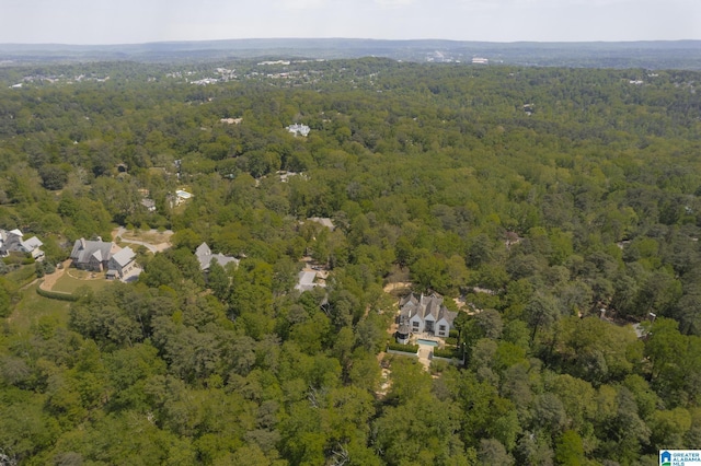 aerial view of property and surrounding area with a heavily wooded area