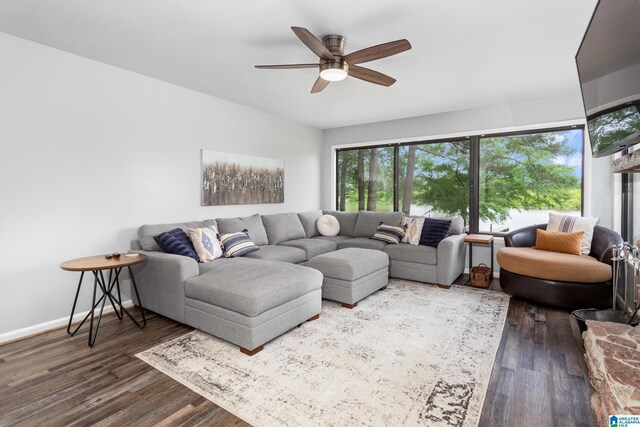 living area with ceiling fan, dark wood-style flooring, and baseboards