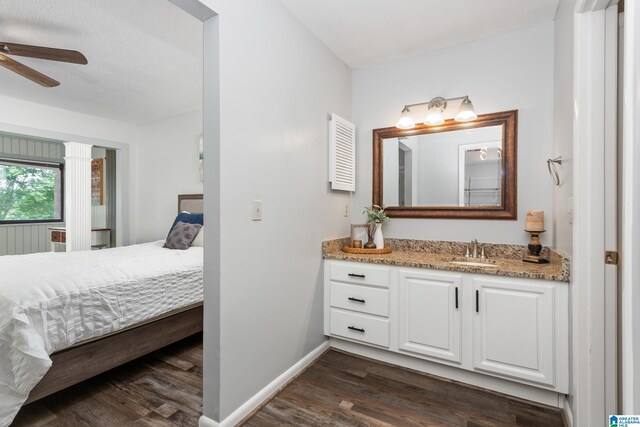 ensuite bathroom with wood finished floors, a ceiling fan, vanity, and baseboards