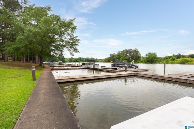 dock area with a water view and a lawn