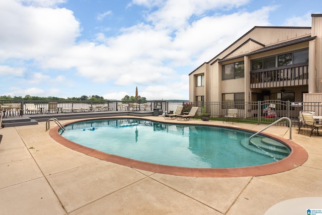 community pool with fence and a patio area