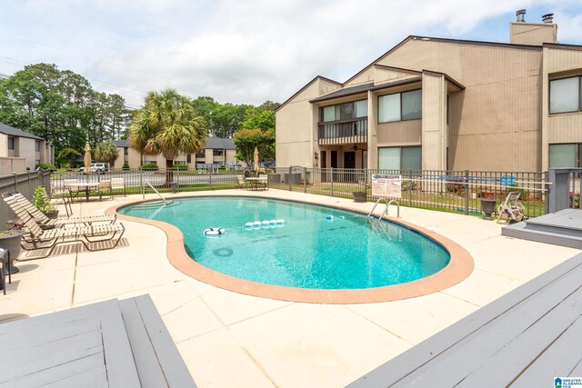 community pool featuring fence and a patio area