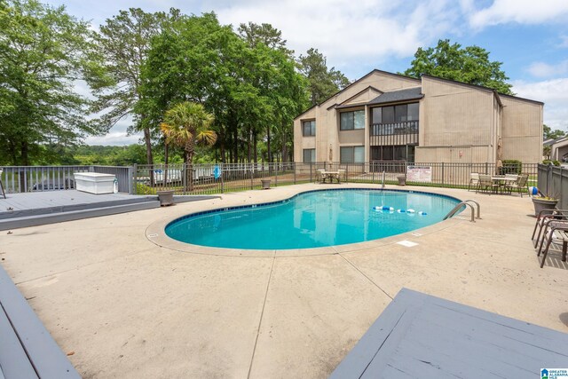 community pool featuring fence and a patio area