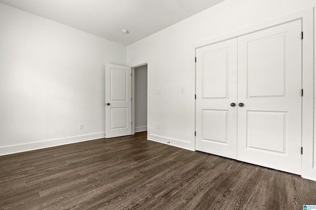 2213 3rd Ave S, Irondale, AL 35210 - unfurnished bedroom featuring dark wood-style flooring, baseboards, and a closet