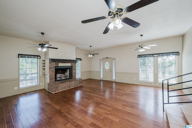 1492 Paul Allman Rd, Adger, AL 35006 - unfurnished living room with hardwood / wood-style floors, a fireplace with raised hearth, ceiling fan, a textured ceiling, and stairway