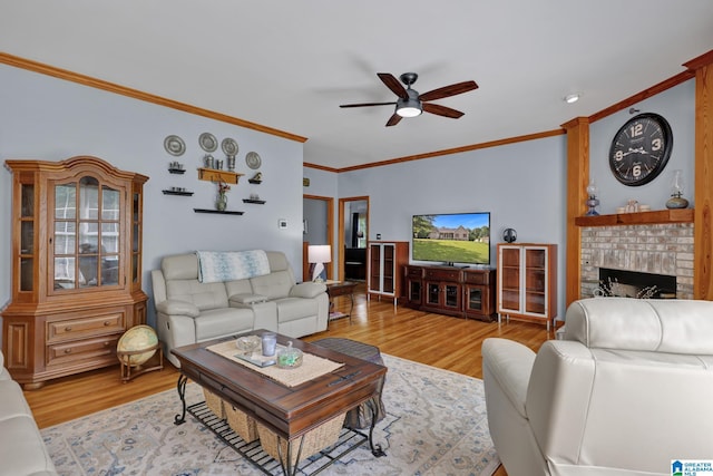 154 Baron Dr, Chelsea, AL 35043 - living room with crown molding, a ceiling fan, light wood-style flooring, and a brick fireplace