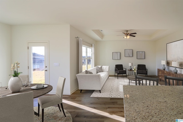 561 Boxwood Bnd, Calera, AL 35040 - living room with wood finished floors, a tray ceiling, ceiling fan, and baseboards