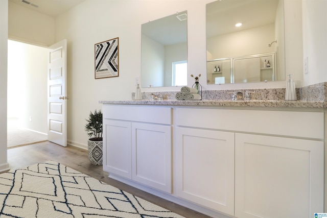 561 Boxwood Bnd, Calera, AL 35040 - bathroom featuring wood finished floors, a stall shower, double vanity, and baseboards
