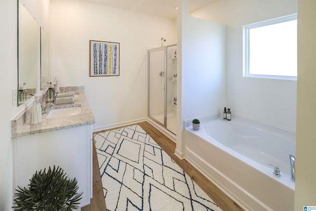 561 Boxwood Bnd, Calera, AL 35040 - bathroom with wood finished floors, a garden tub, a shower stall, and vanity