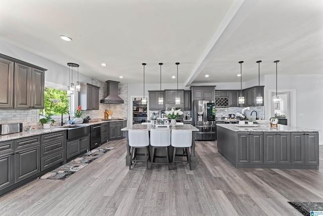 7 Stillwaters Trl, Sylacauga, AL 35151 - kitchen featuring wall chimney exhaust hood, a center island, appliances with stainless steel finishes, decorative backsplash, and a sink
