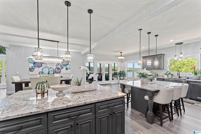 7 Stillwaters Trl, Sylacauga, AL 35151 - kitchen with a center island, a sink, light wood finished floors, decorative backsplash, and a kitchen breakfast bar