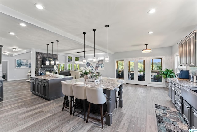 7 Stillwaters Trl, Sylacauga, AL 35151 - dining area featuring light wood-style floors, french doors, recessed lighting, baseboards, and a large fireplace