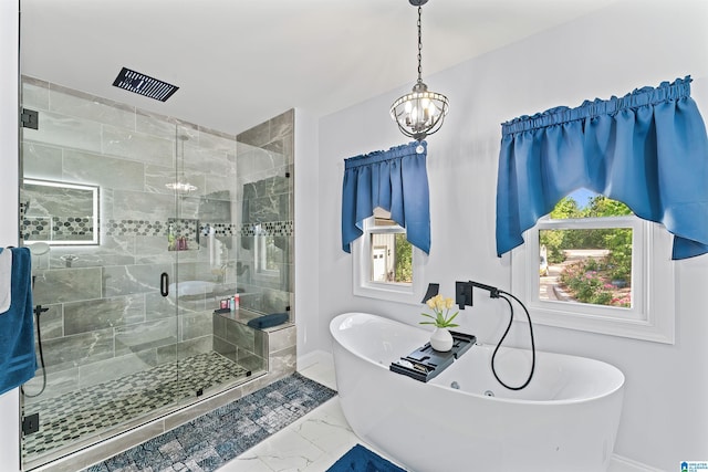 7 Stillwaters Trl, Sylacauga, AL 35151 - bathroom featuring marble look tile flooring, baseboards, a freestanding tub, a chandelier, and a stall shower