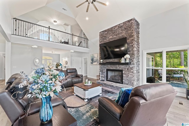 7 Stillwaters Trl, Sylacauga, AL 35151 - living area with ceiling fan, high vaulted ceiling, a stone fireplace, and wood finished floors