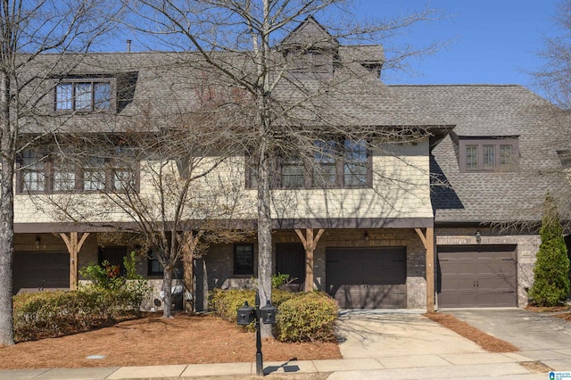 townhome / multi-family property featuring a shingled roof, concrete driveway, and an attached garage