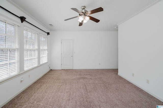 spare room with ornamental molding, carpet floors, ceiling fan, and baseboards