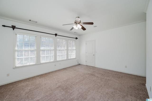 empty room with crown molding, a ceiling fan, carpet flooring, and baseboards